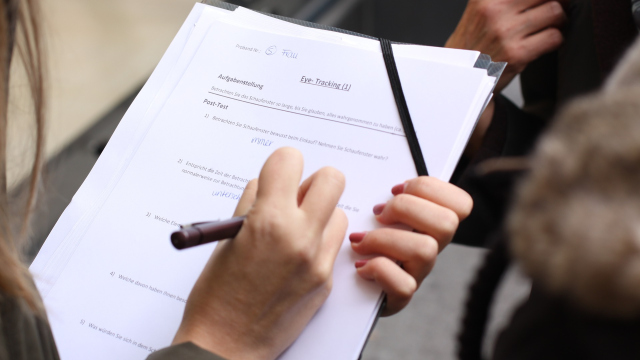 Abbildung von Haenden und einem Stift auf einem Ausfuellbogen Papier