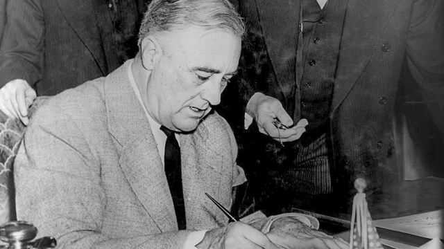 Abbildung des US President Franklin D. Roosevelt beim unterzeichnen des Dokuments zum Eintritt in den Zweiten Weltkrieg
