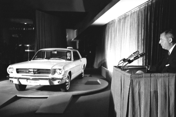 Abbildung von einem Ford Mustang und dessen Entwickler Lee Iacocca
