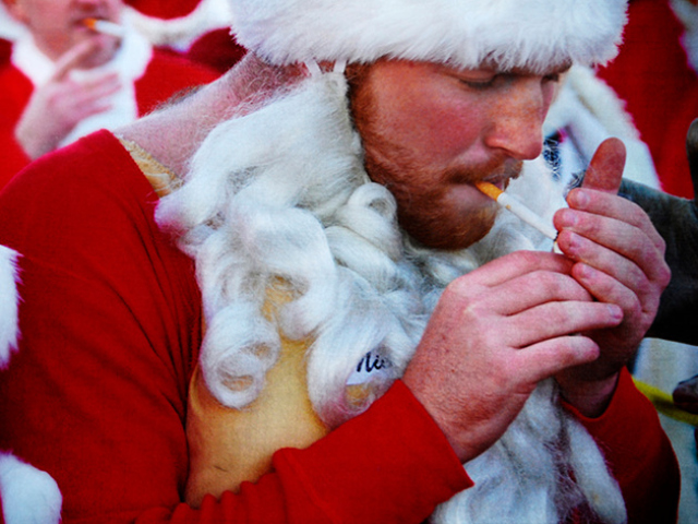 Abbildung von Mann verkleidet als Weihnachtsmann der raucht