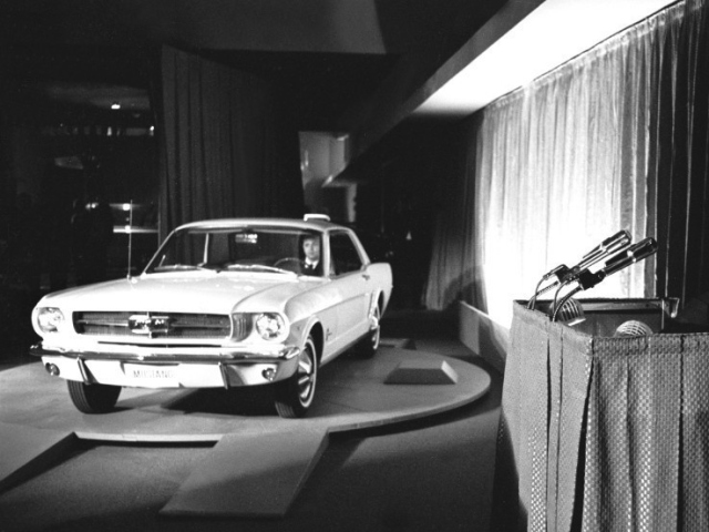 Abbildung von einem Ford Mustang und dessen Entwickler Lee Iacocca